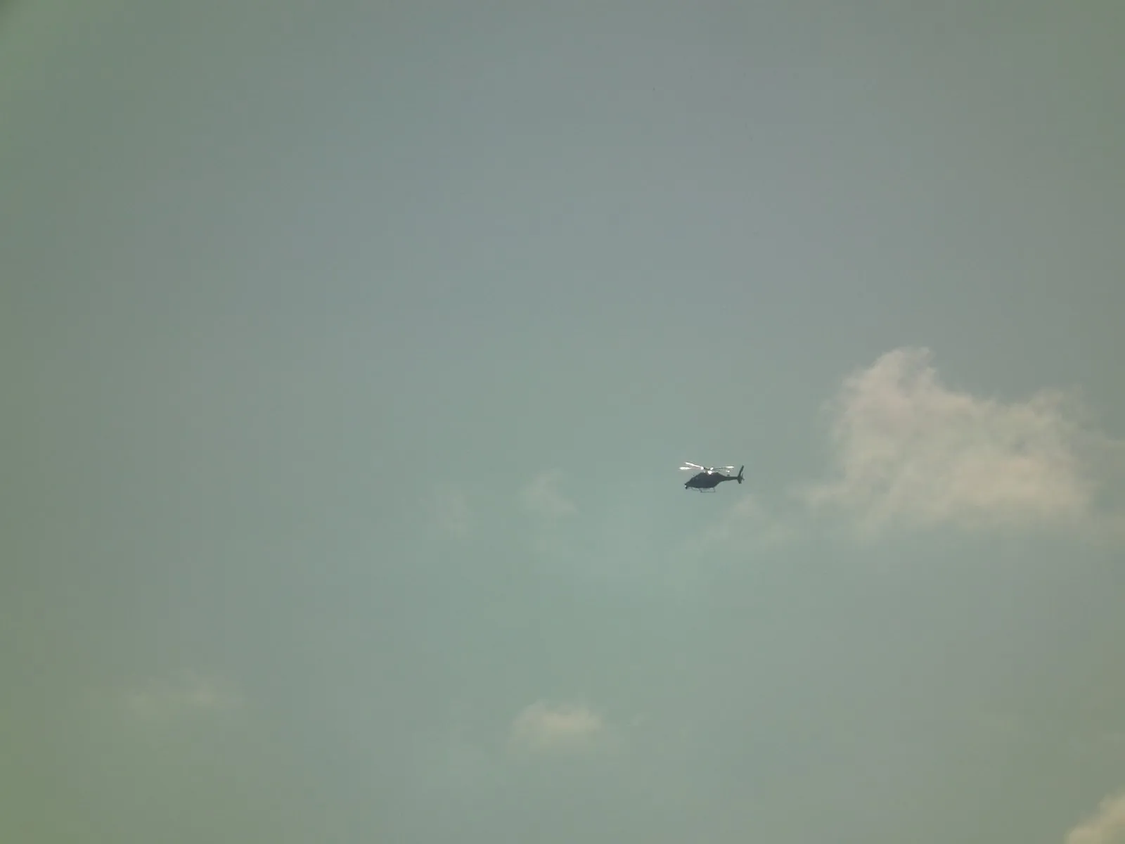Mavi gökyüzünde uçan helikopter